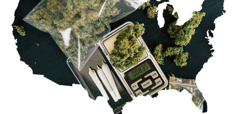 A black silhouette outline of the United States, partially filled in by baggies of cannabis, rolled joints, and a scale.