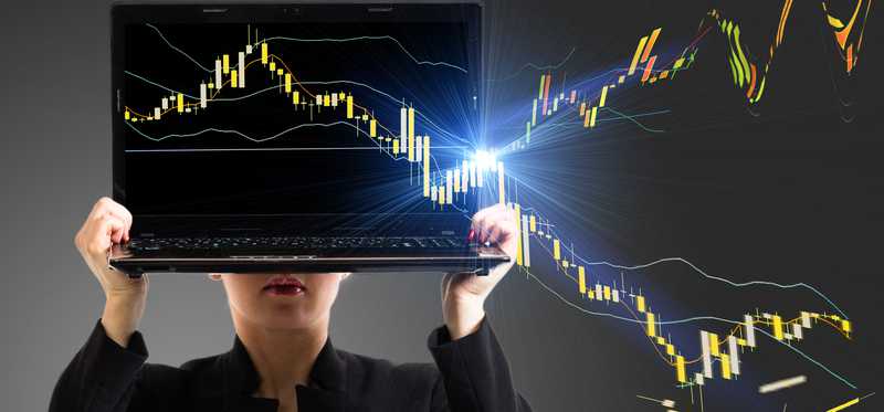 A businesswoman holding a laptop, with a stock chart coming out of the screen and heading both higher and lower.