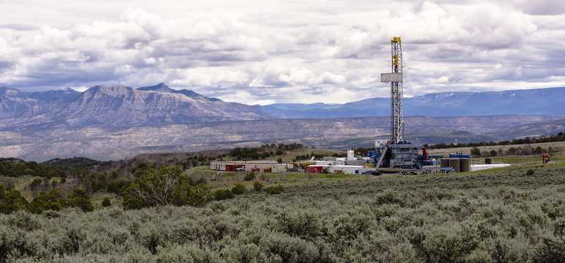A drilling rig with the mountains in the background.