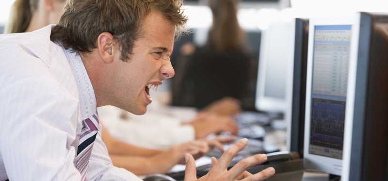 A frustrated man yelling at his computer screen.