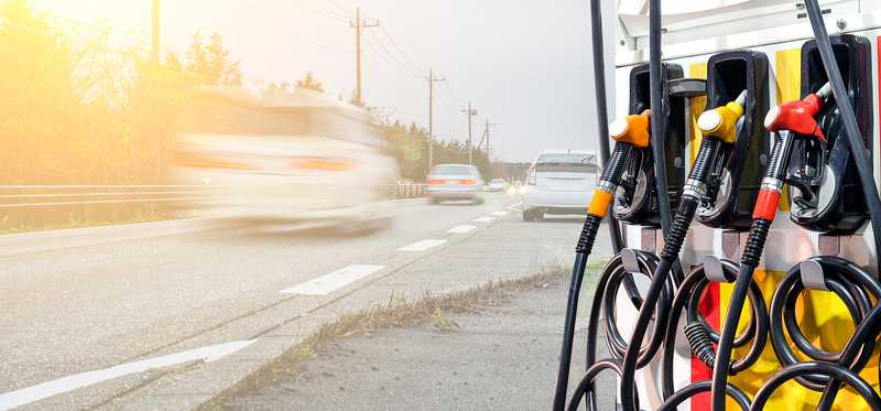 A fuel pump with a blur of cars next to it.