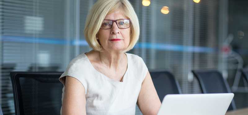 A mature businesswoman sitting in front of her laptop in her office.