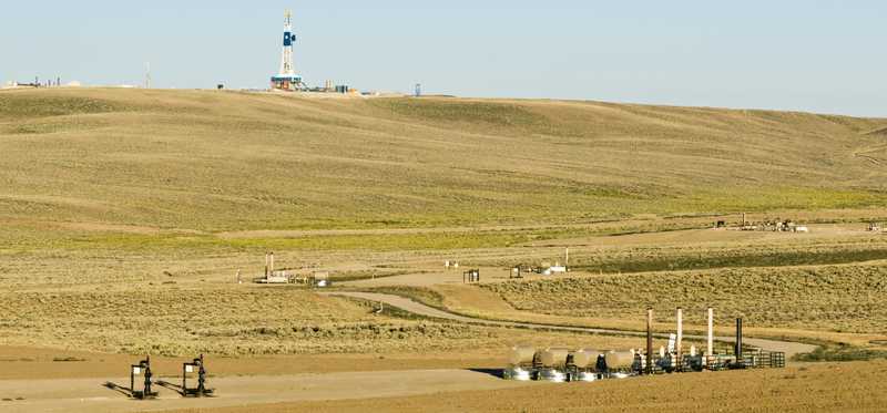 A natural gas field with a drilling rig.