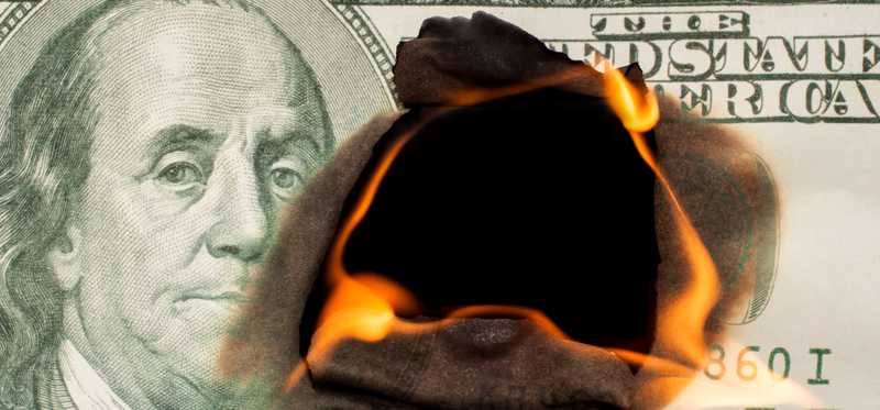A one hundred dollar bill burning from the center outward.