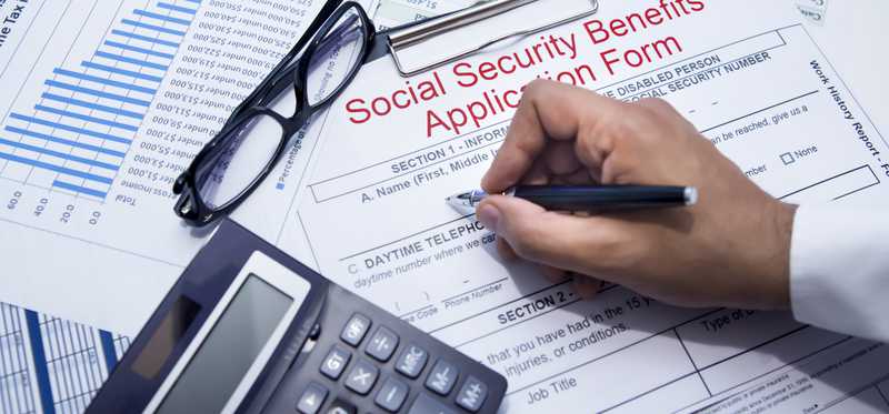 A person filing out a Social Security benefits application form.