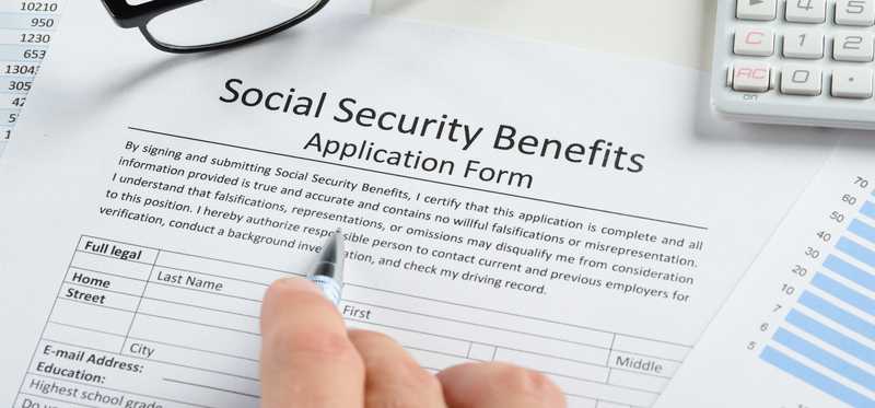 A person filling out a Social Security benefits application form.
