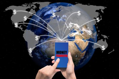A person using a smartphone to transfer money to various points all over the world