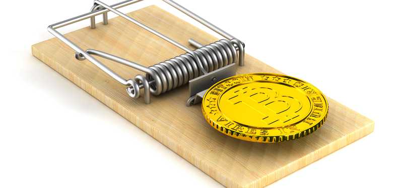A gold coin marked with a B inside of a mouse trap.