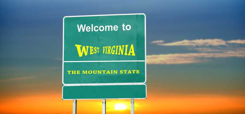 A road sign reading welcome to West Virginia, the Mountain State.