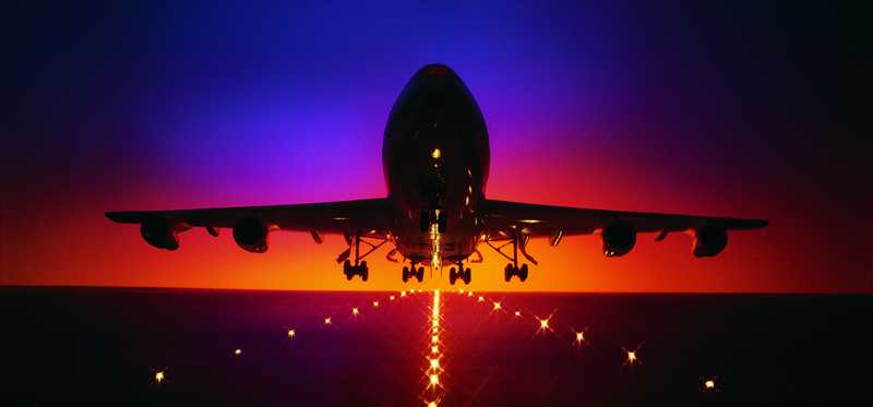 An airplane taking off at sunset.