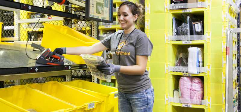 Woman packing an Amazon order in a fulfillment center.