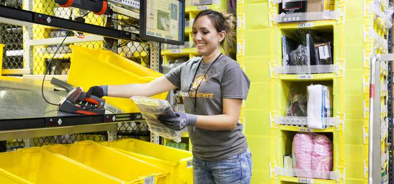 An Amazon fulfillment employee preparing goods for shipping.