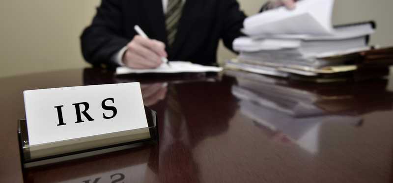 An IRS agent reviewing documents at a desk.
