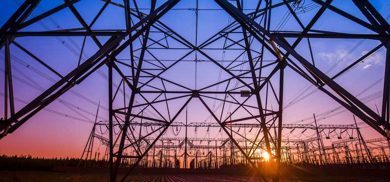An electricity transmission pylon in the evening.