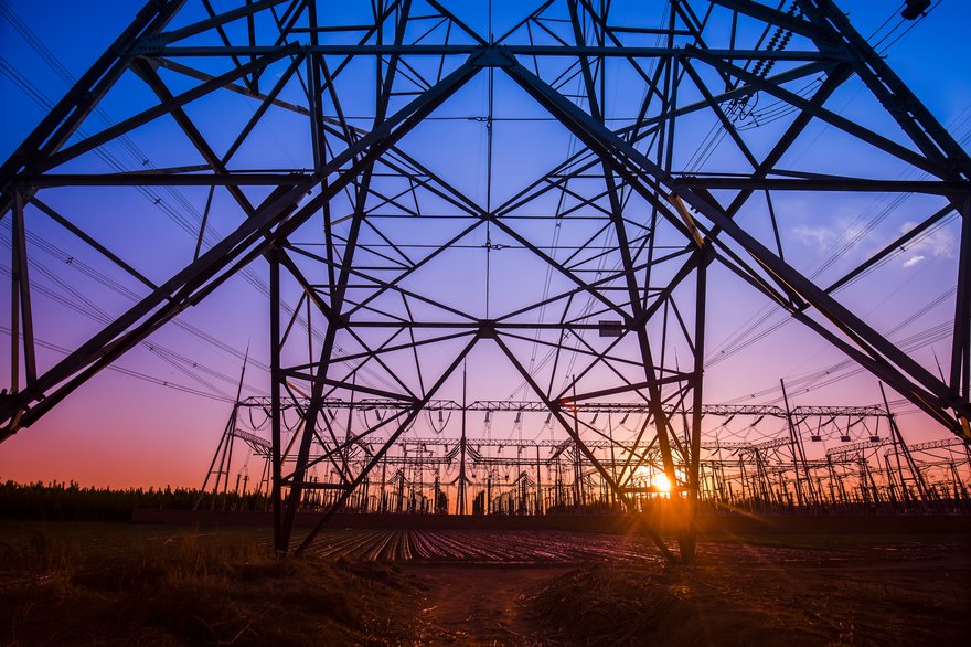 An electricity transmission pylon in the evening.