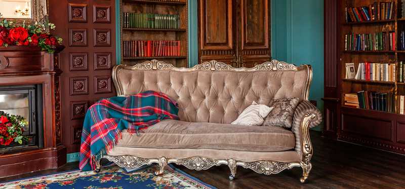 Antique study with couch and built-in bookshelves.