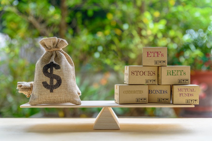 Burlap sack of money balanced on a seesaw versus stocks, bonds, and more.