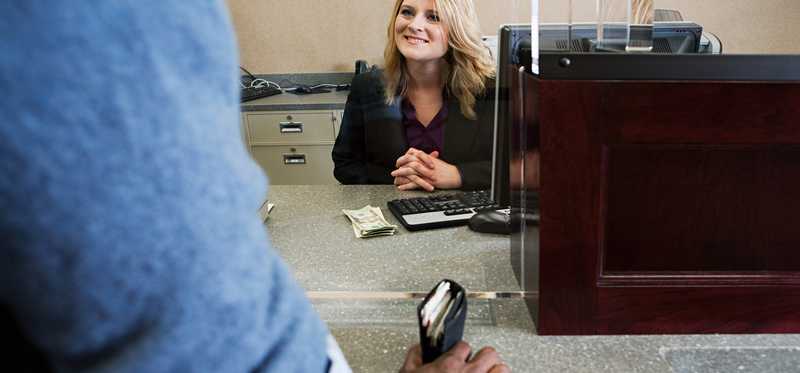 A bank teller smiles at a customer.