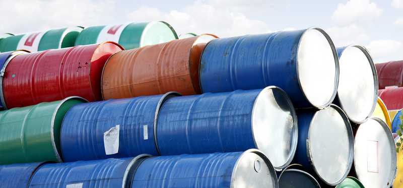 Barrels of crude oil stacked atop one another.