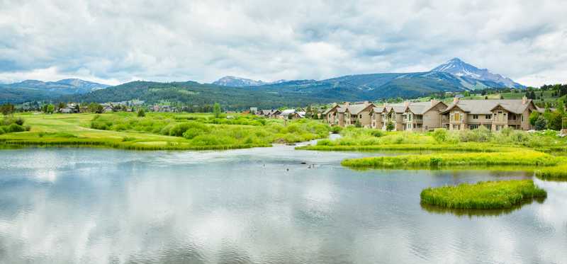Mountains in background and condos in foreground in Big Sky, Montana.