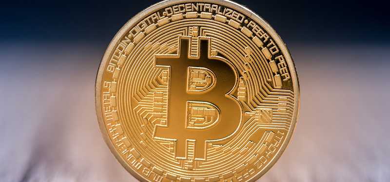 A gold coin with the Bitcoin symbol.