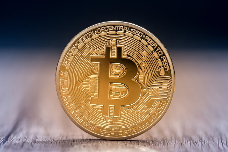 A gold coin with the Bitcoin symbol.