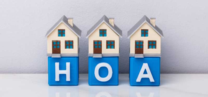 Blocks spelling out HOA with model houses on top of them.