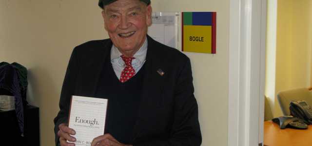 Jack Bogle standing at Fool HQ wearing a Fool hat.