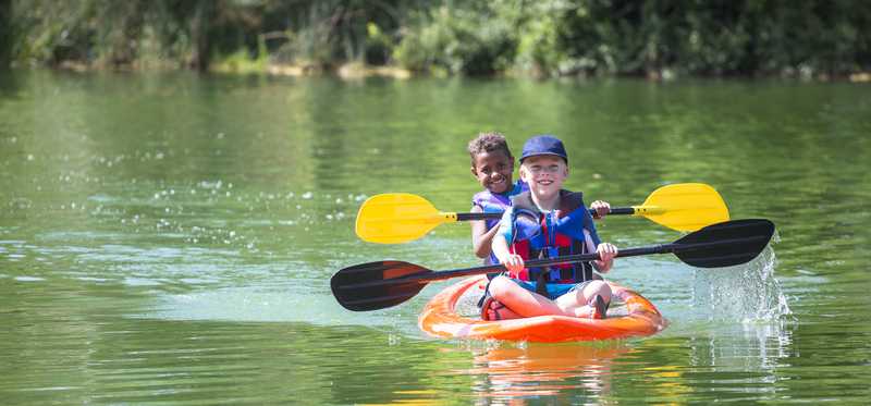 Boys kayaking on a river.
