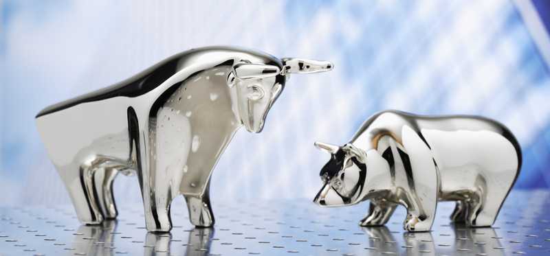 A metal figurine bull and bear face off.