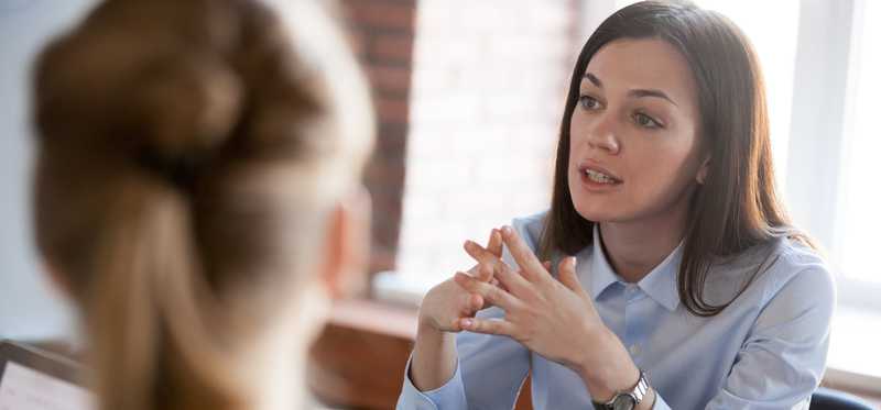 Businessperson speaking to someone in office.