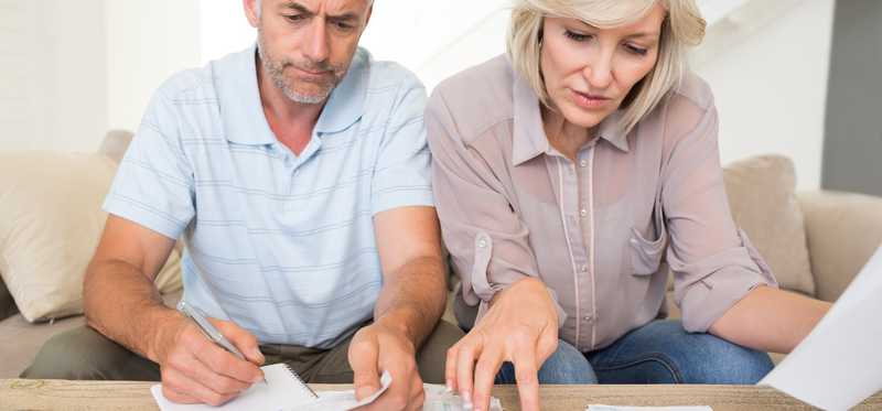 People using calculator with paperwork.