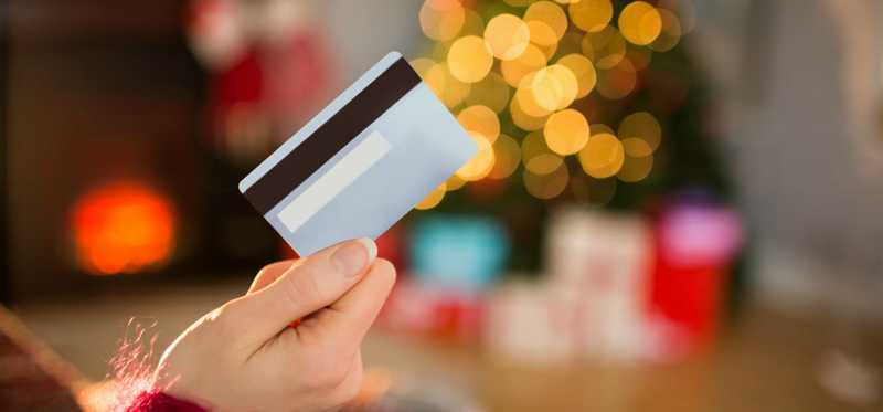 A hand holds a credit card.
