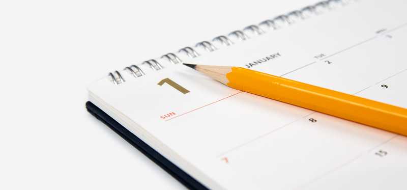 Calendar with pencil sitting on top.