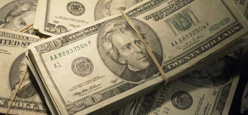 Piles of twenty dollar bills bound with rubber bands.