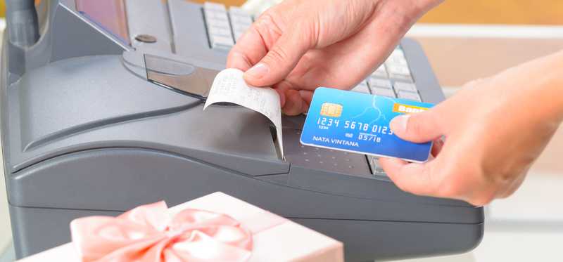 Cashier holding credit card and receipt