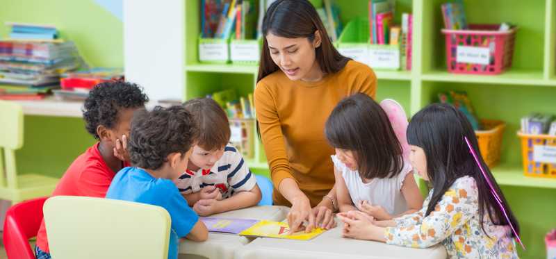 A child care provider working with a group of children.