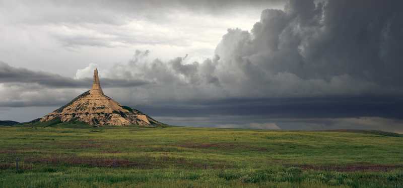 Chimney Rock in Nebraska with storm clouds in the distance