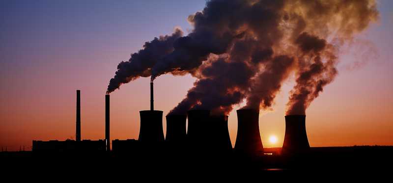 Silhouette of a coal fired power station at sunset.