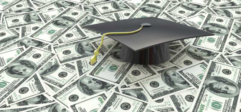Graduation cap sitting on top of a pile of cash.