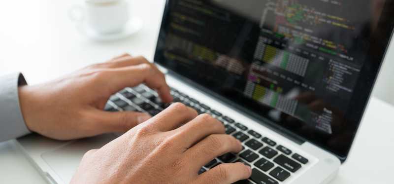 A close-up of someone typing on a laptop