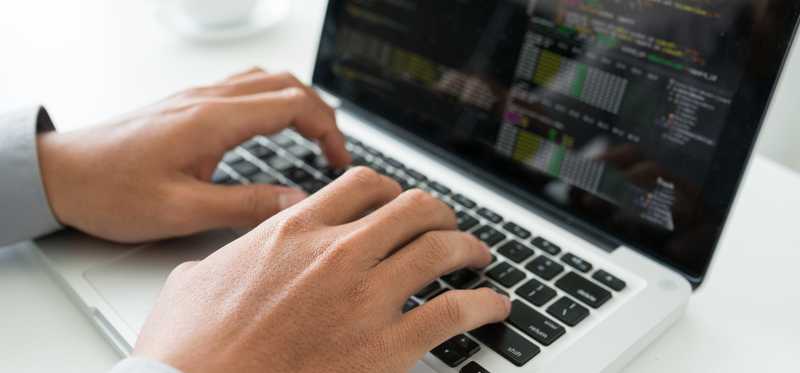 A close-up of someone typing on a laptop