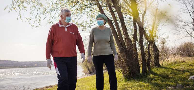 Senior couple outside wearing masks and gloves