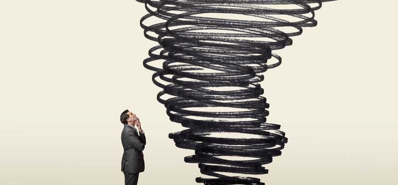 Man in suit looking curiously at illustration of funnel cloud forming