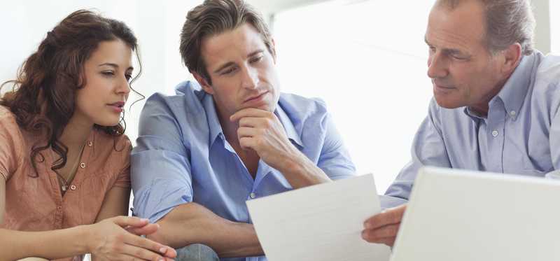 Advisor meeting with clients and reviewing paperwork.