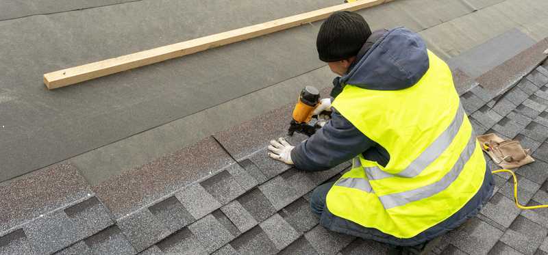 Construction worker installing new roof.