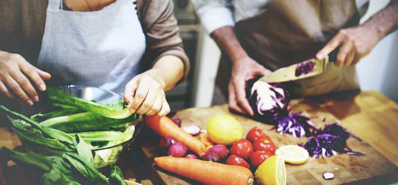 Couple preparing meal together using fresh ingredients.