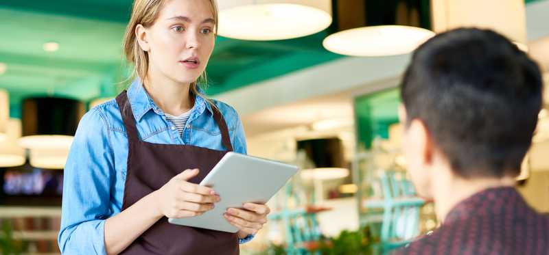 Waitress speaking with her male customer.