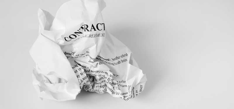 A contract printed on white paper and crumbled into a ball.