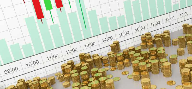 Stacks of physical crypto coins stacked in front of a virtual currency price chart.